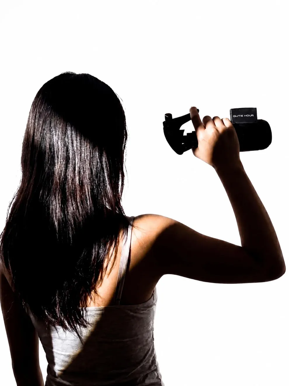 QUIET HOUR — backlit figure holding a black spray object in a restrained editorial scene